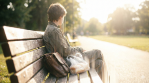 少子高齢化について考えるのをやめてベンチに座る若者のイメージ